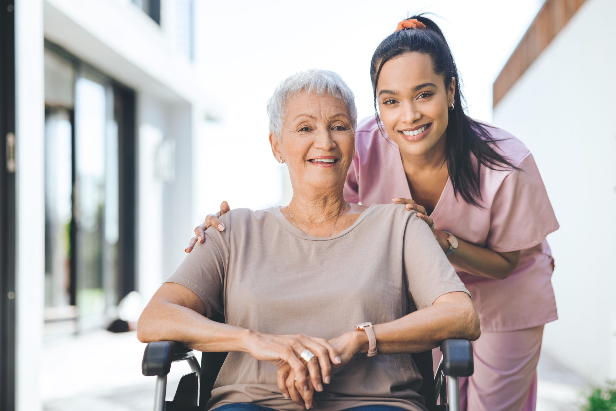Nurse helping elderly patient leave hospital in a wheelchair